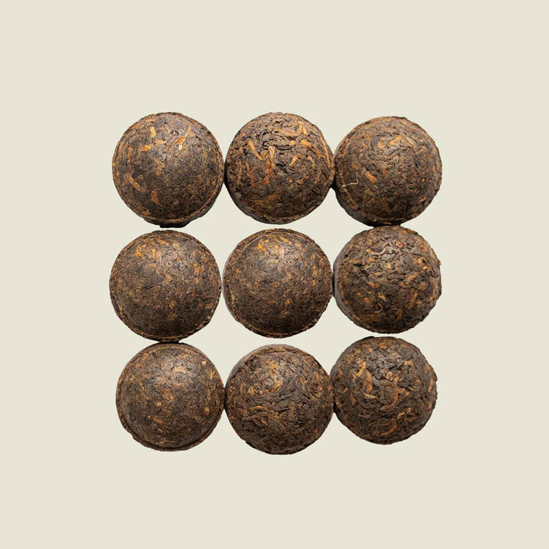 Kleine Pu Erh-Törtchen von oben fotografiert, kompakt gepresst und dunkel – Mini Tuo Cha von Noema.