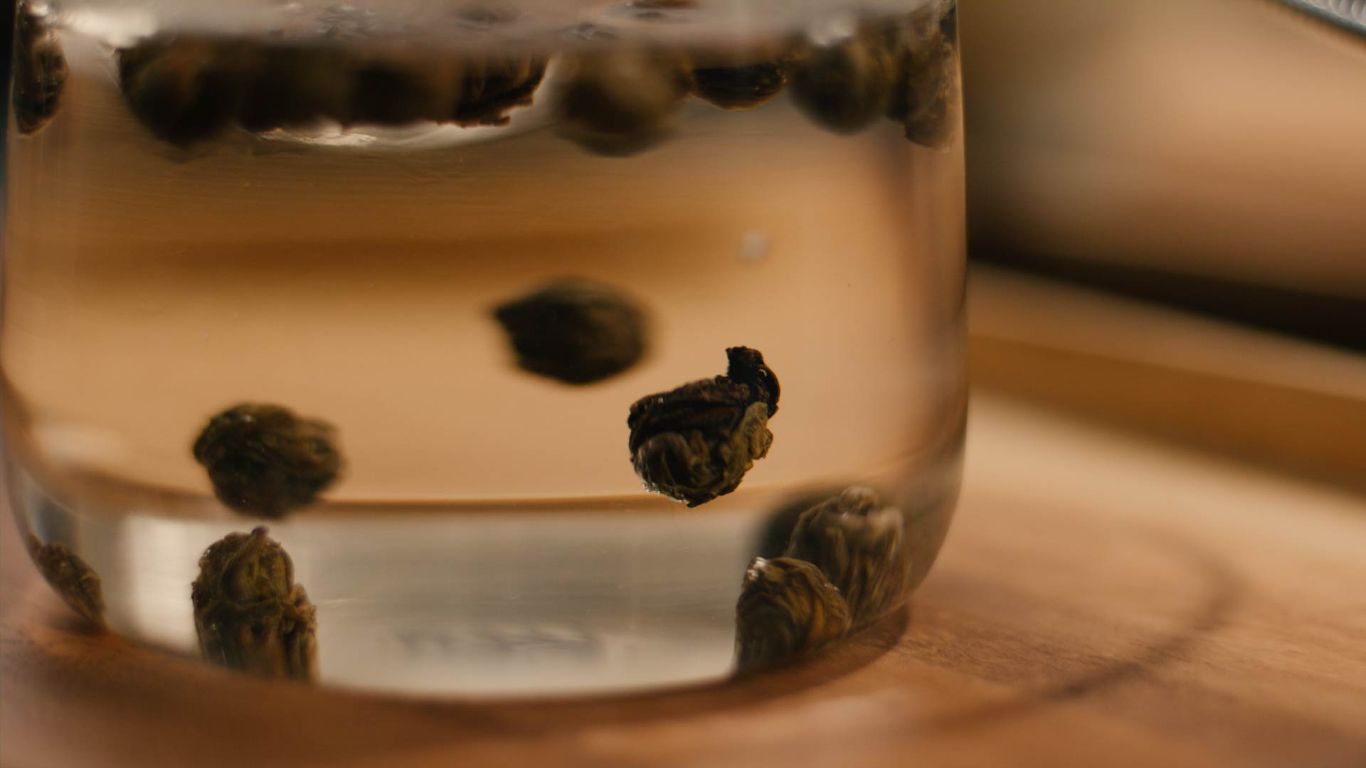 Jasmin Dragon Pearls schwimmen in heißem Wasser in einer Glaskanne